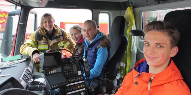 Feuerwehrfrau Stefanie Höhn erklärt den Feuerwehr-Kids die Funktion des Gerätewagens zur Ölschadenbekämpfung.