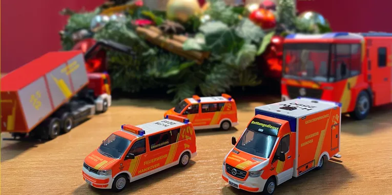 Ein Adventskranz und Miniaturautos der Feuerwehr