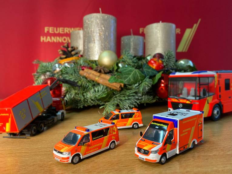 Ein Adventskranz und Miniaturautos der Feuerwehr