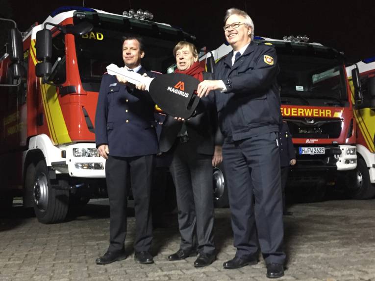 Stadtbrandmeister Wilke bekommt einen symbolischen Schlüssel bei der offiziellen Fahrzeugübergabe von Feuerwehrdezernent Härke und Fachbereichsleiter Lange übergeben (v.l.).