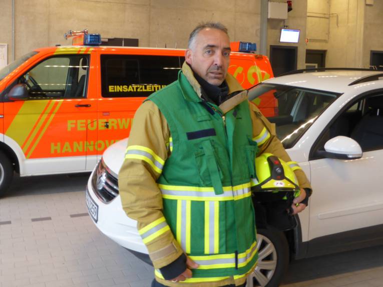 Ein Mann steht vor einem Auto