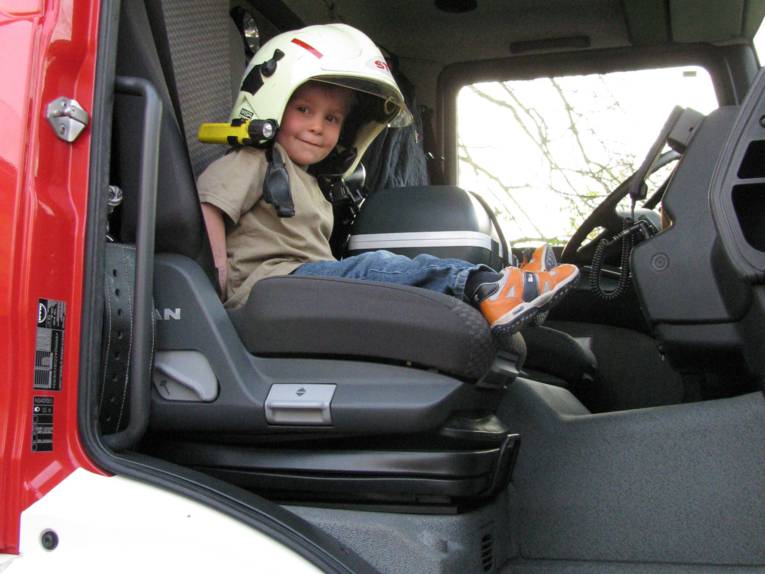 Kind mit Helm im Löschfahrzeug