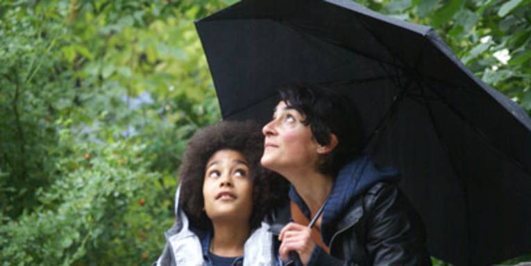 Mutter und Kind unter einem Schirm
