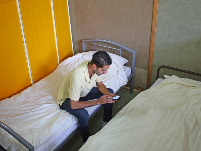 Ein Flüchtling liest Nachrichten auf seinem Handy