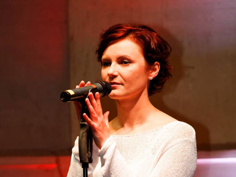 Portraitaufnahme der Sängerin Anna Nova am Mikrofon
