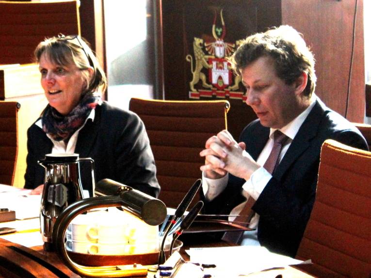 Zwei Personen sitzen im Hodlersaal hinter Pulten