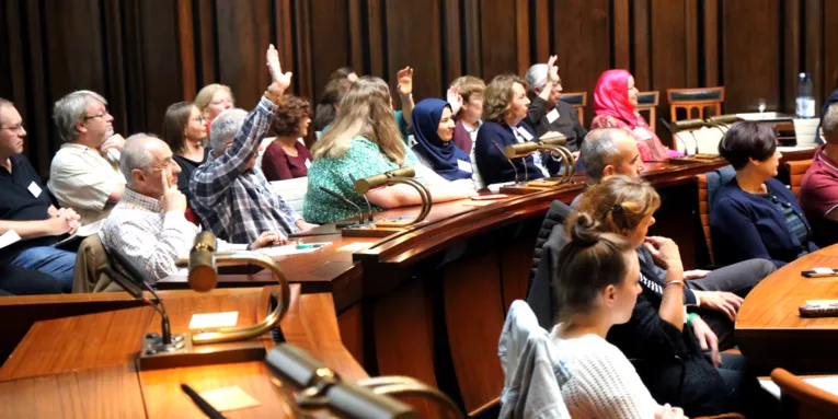 Etwa 30 Personen sitzen im Hodlersaal des Neuen Rathauses.