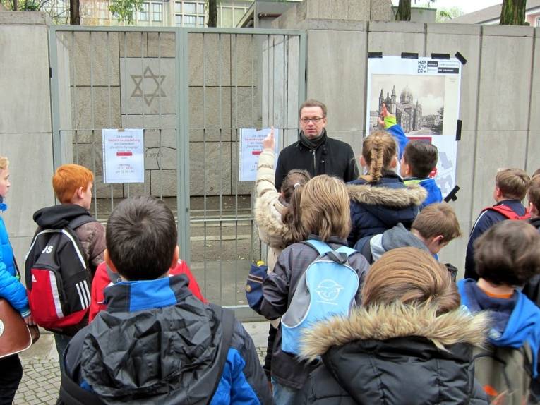 Dr. Günter Max Behrendt erklärt die Geschichte der zerstörten Synagoge am Mahnmal in der Rote Reihe.