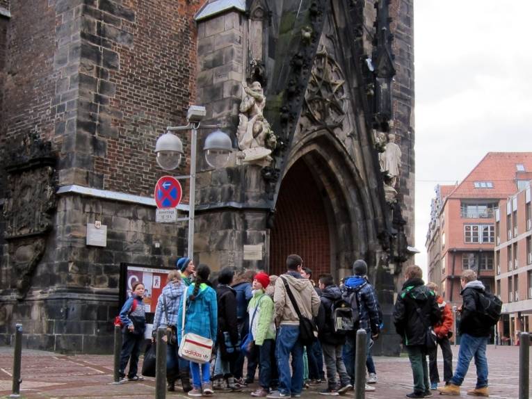 Eine Gruppe von Schüler/innen steht vor dem Eingangstor der Marktkirche