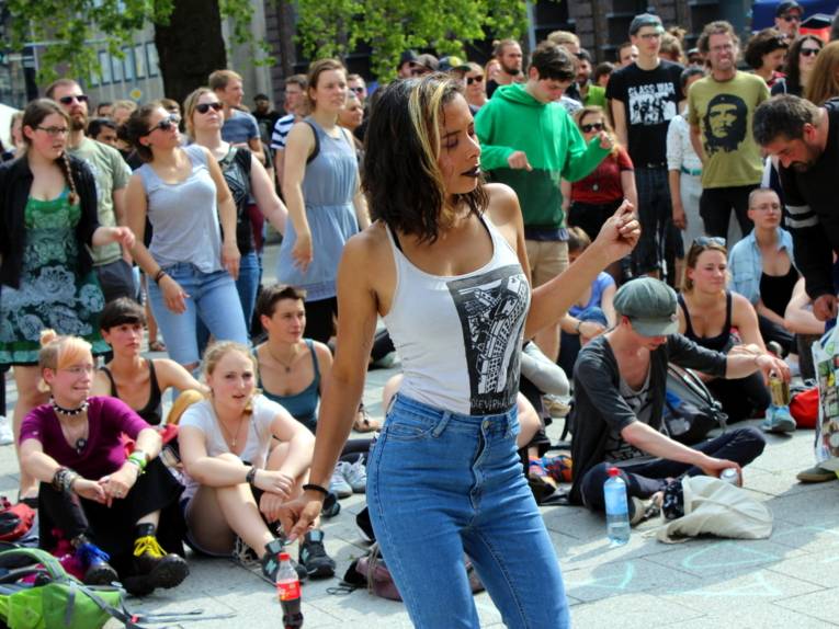 Eine Frau tanzt vor einer großen Menge von Zuschauer/innen.