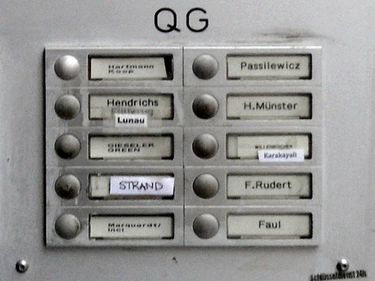 Ein graues Klingelschild im Eingangsbereich eines Hauses