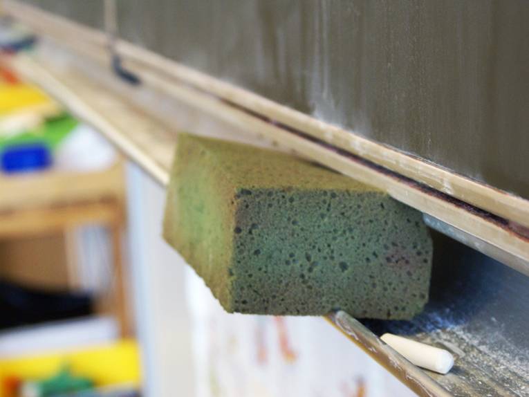 Ein Tafelschwamm in der Ablage unterhalb einer Schultafel