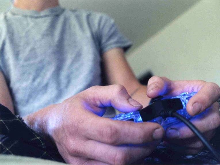 Nahaufnahme von Händen an einer Playstation