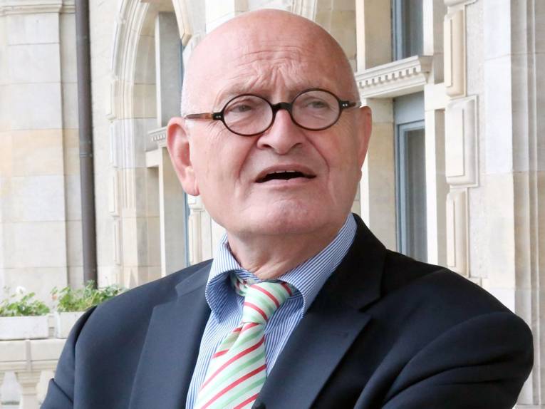 Ein Senior mit Brille im Anzug.