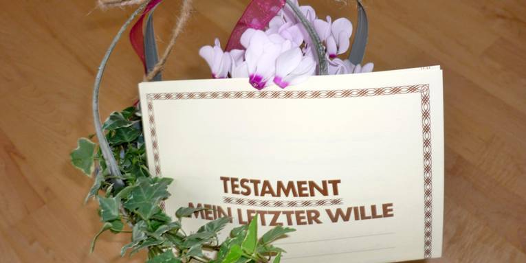 Testamentbrief vor einem Blumenarrangement