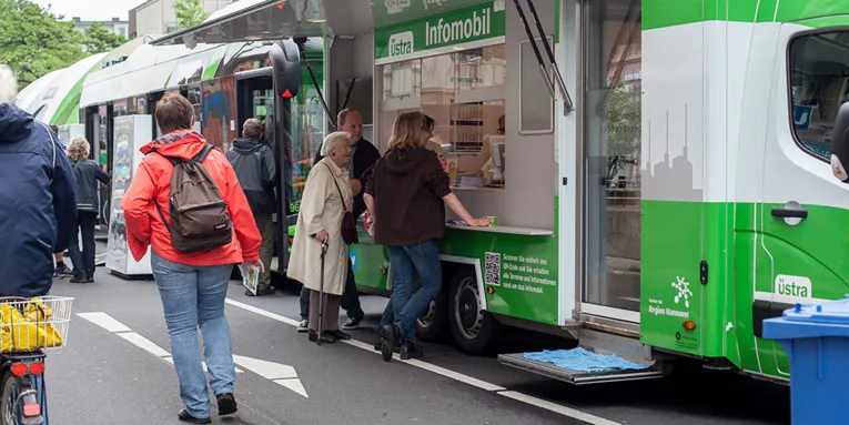 Am Info-Mobil der üstra informieren sich Passanten über Angebote des öffentlichen Nahverkehrs.