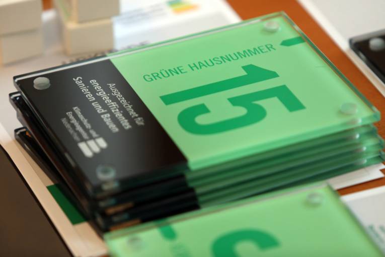 Schilder der "Grünen Hausnummer" gestapelt