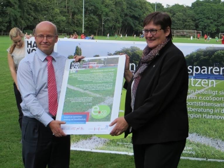 Erste Stadträtin Sabine Tegtmeyer-Dette übergibt die Abschlussurkunde an den Vereinsvorsitzenden Günter Lenz vom TuS Mecklenheide