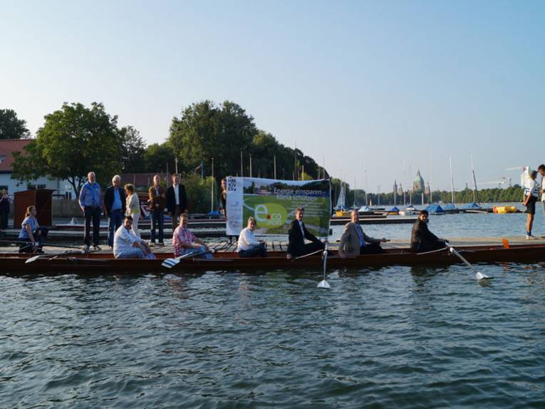 Vereinsmitglieder sitzen gemeinsam mit den Dezernenten in einem Ruderboot