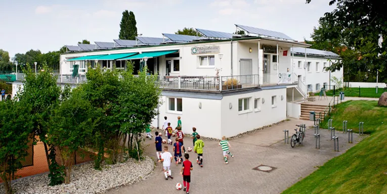 Fußballnachwuchs vor Clubgaststätte mit Solardach