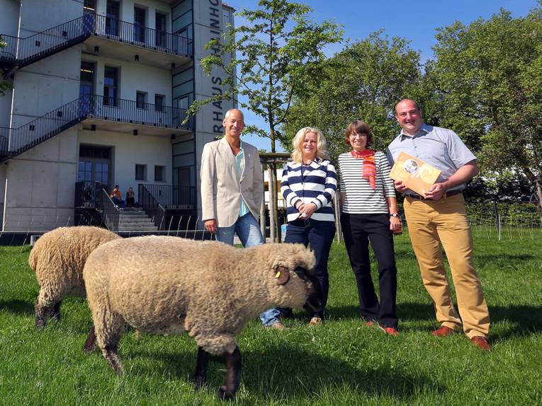 Energieberater Roland Beckedorf, Bezirksbürgermeisterin Edeltraut Geschke, Anke Unverzagt von proKlima und Christoph Felten von der Klimaschutzagentur mit Schafen vor dem Kulturhaus Hainholz