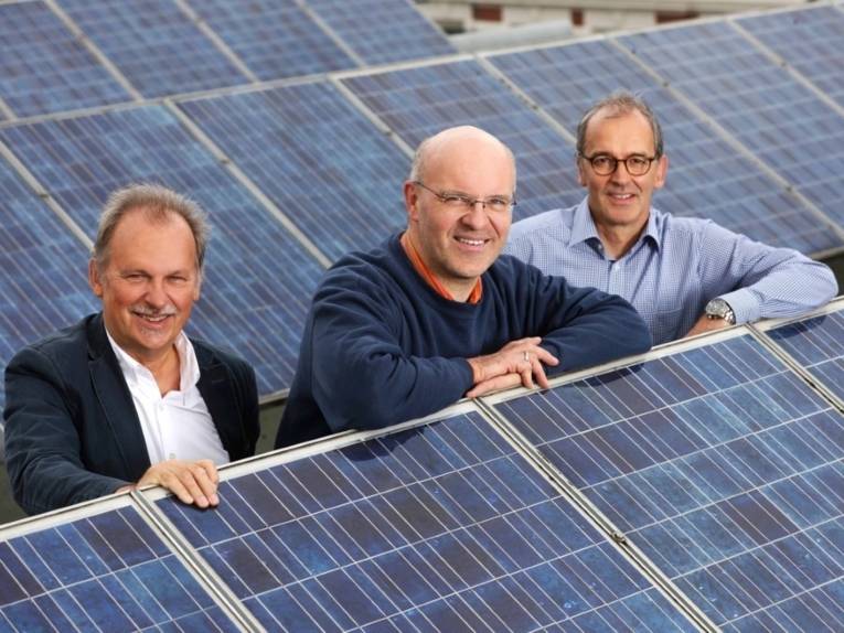 Die drei hannoverschen Solar-Coaches von links: Andreas Lau, Dirk Hufnagel und Ludwig Brokering stehen zwischen einer Photovoltaikanlage