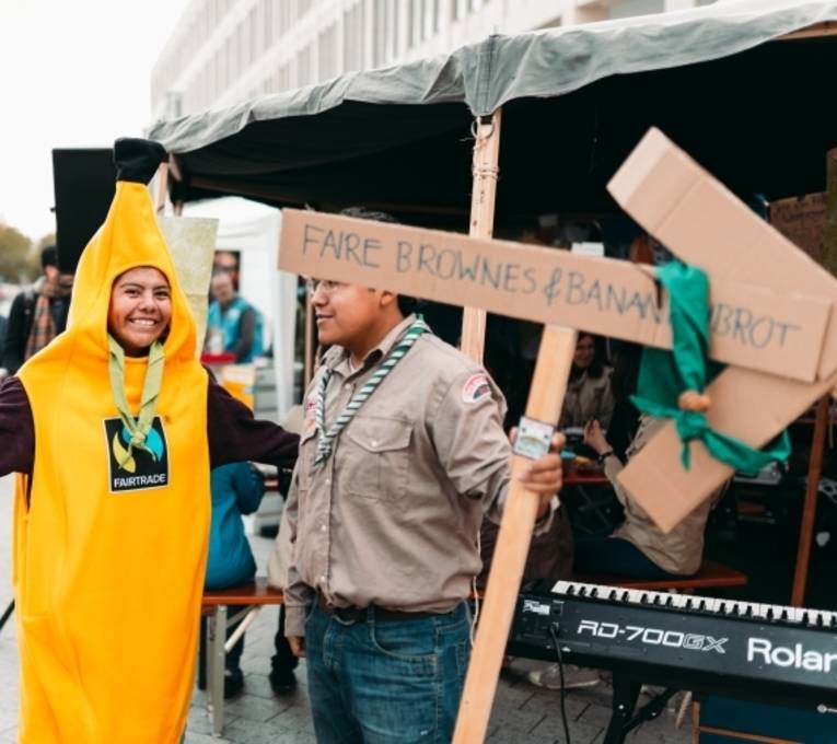 Eine Person in einem Bananenkostüm und eine weitere Person mit einem Schild