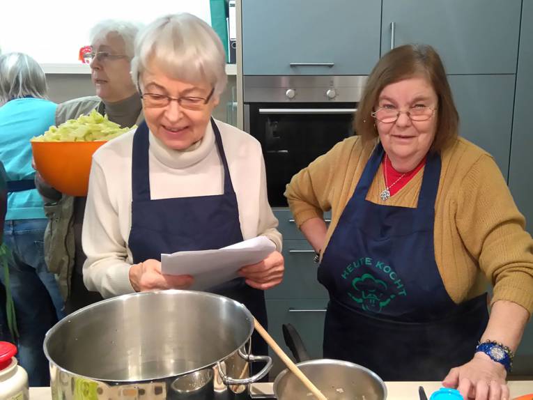Vier Teilnehmerinnen eines Kochkurs in einer Küche