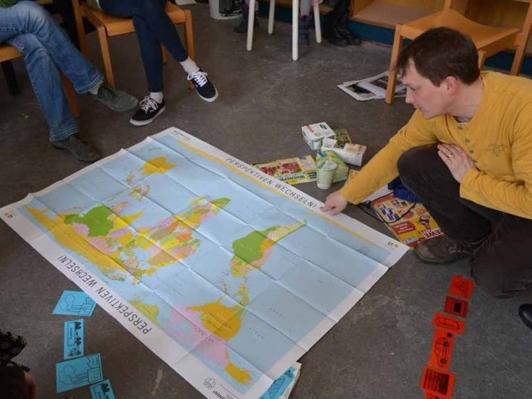 Junger Mann, der auf eine Karte zeigt. 