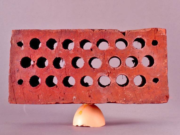 Backstein liegt auf einer umgedrehten halben Eierschale