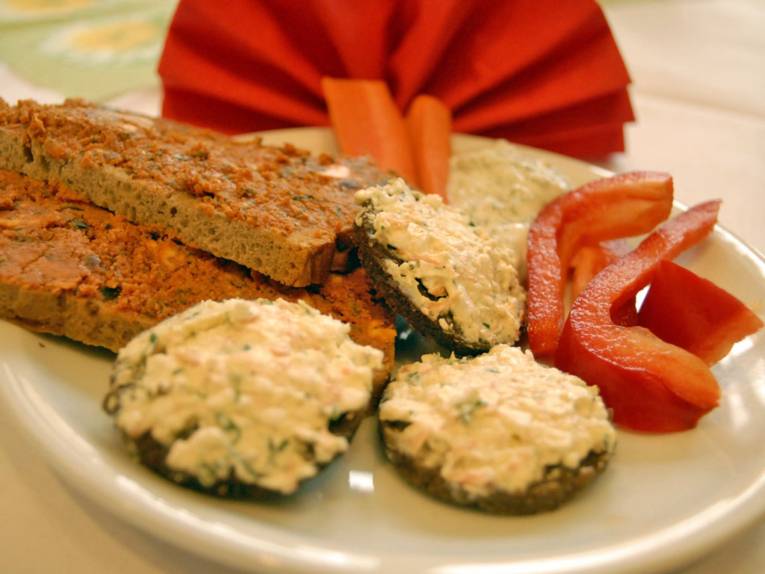 Ein Teller mit Schnittchen mit gesundem Aufstrich und mit frischen Paprikascheiben