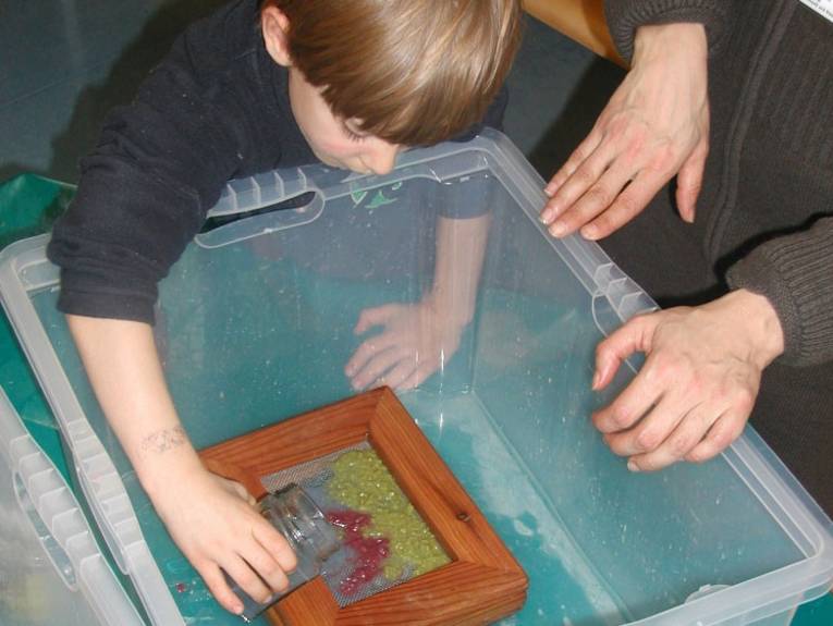 Ein Junge schöpft Papier