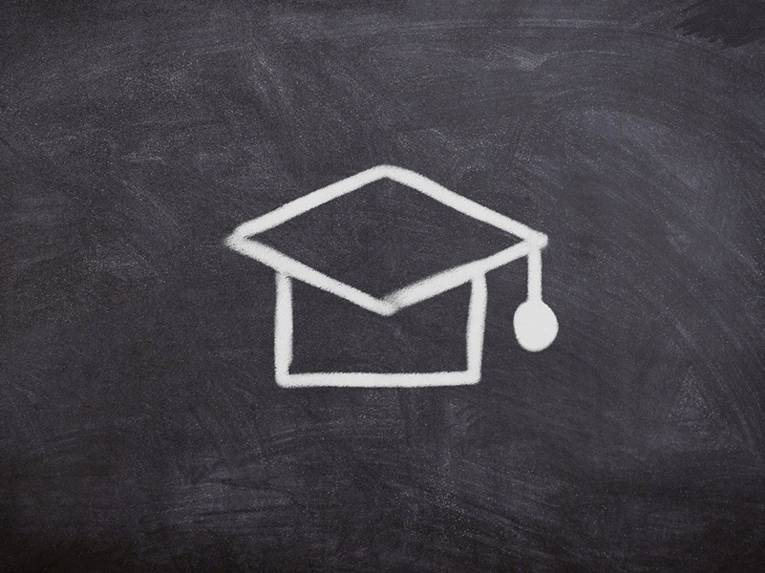 Ein Doktorhut ist symbolisch mit weiß auf einer schwarzen Tafel aufgemalt.