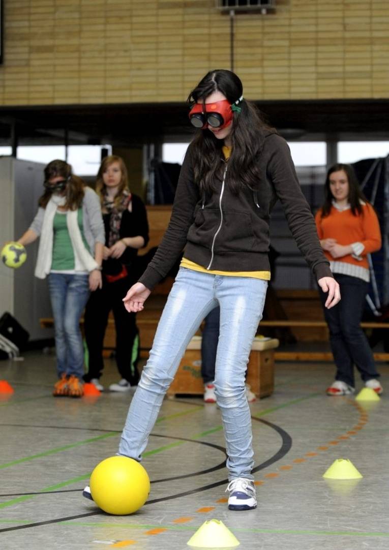 Ein junge Frau bewältigt einen Hindernisparcours mit Rauschbrille