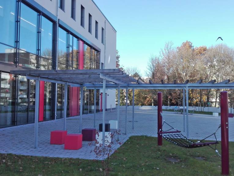 Außenansicht des Jugendzentrums Mühlenberg mit Außenbereich (Hängematte, Tischtennisplatte)