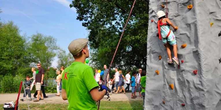 Ein Kind erklimmt einen Kletterberg.