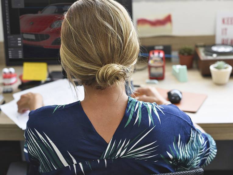 Junge Frau sitzt an einem Schreibtisch