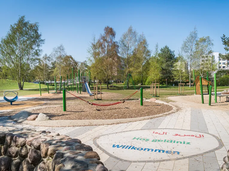 Ein Stadtteilpark mit Spielgeräten. 