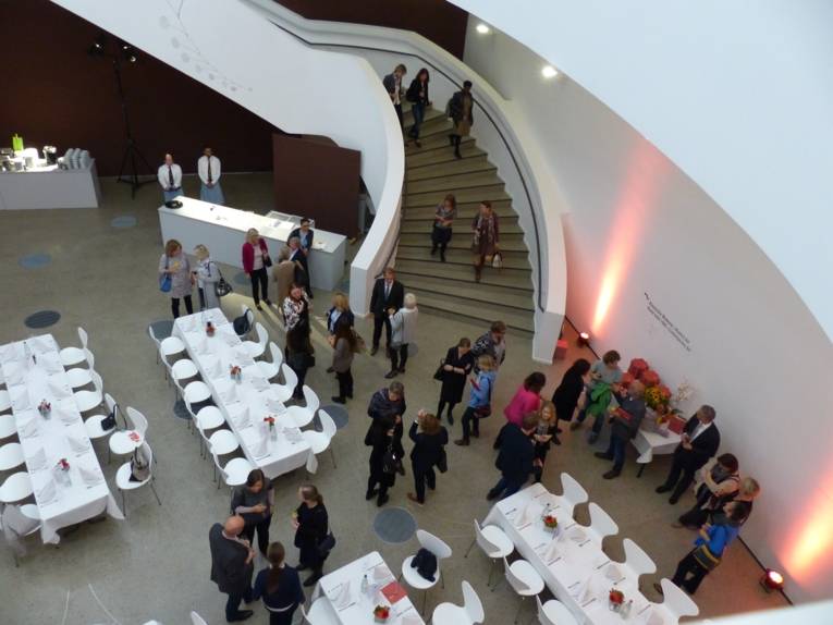 Blick von oben auf die ankommenden Gäste im Caldersaal im Sprengelmuseum