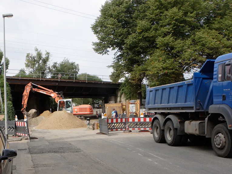 Straßen- und Brückenbaustelle mit Bagger und LKW
