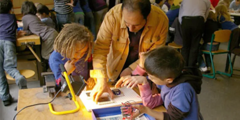 Ein Lehrer erklärt Schülern ein Experiment
