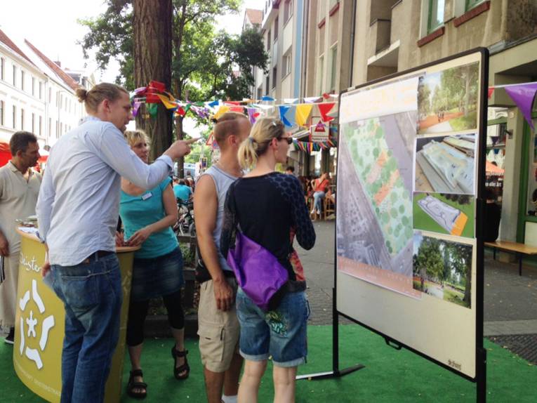 Interessierte informieren sich beim Deisterstraßenfest mittels einer Schautafel über den geplanten Park.