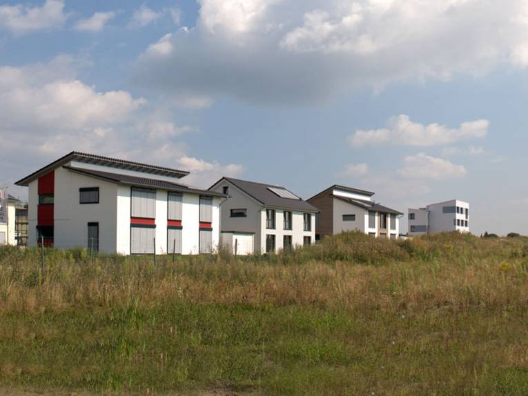 Baugrundstücke mit Neubauten im Hintergrund