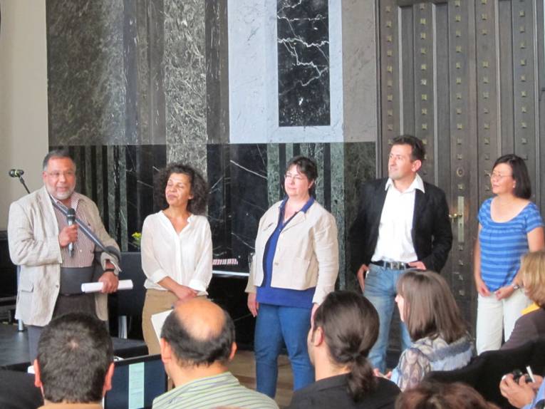 Drei Vertreterinnen und zwei Vertreter von verschiedenen Migrantenorganisationen im Mosaiksaal des Neuen Rathauses

