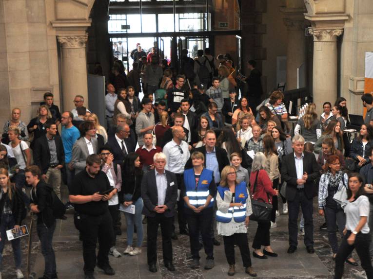 Menschen in einer Halle. 