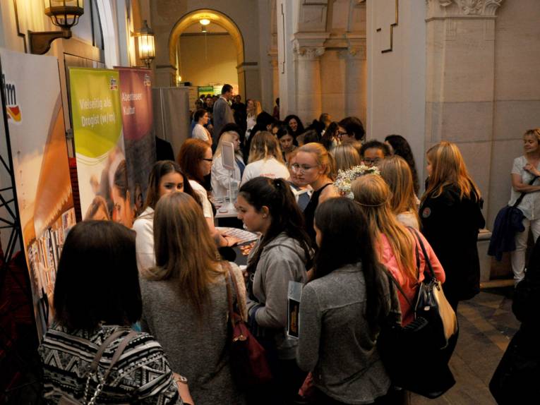Menschen in einem Flur vor einem Stand. 