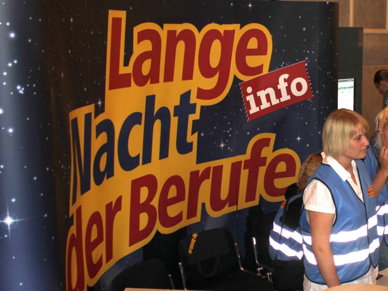 Junge Frau an einem Informationsstand der Langen Nacht der Berufe