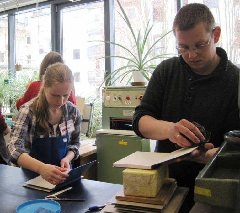 Buchbinder beim Bearbeiten von Medien