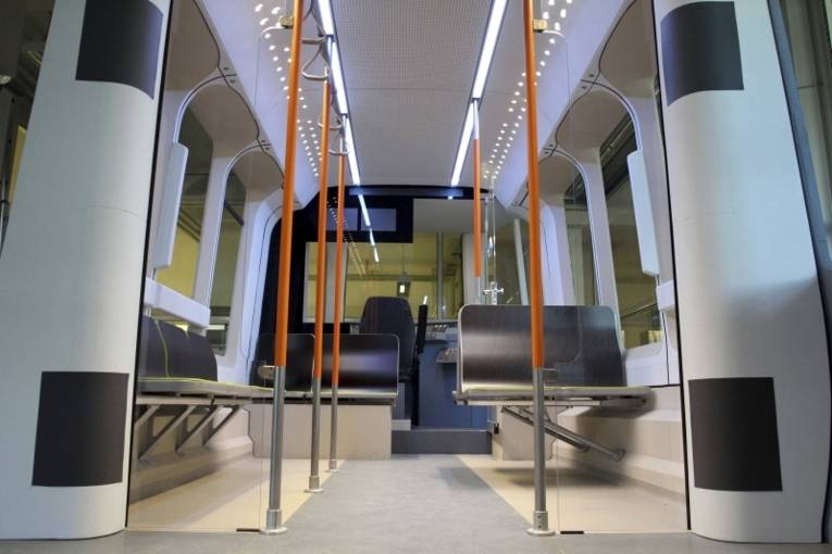 Das Modell des neuen Stadtbahnfahrzeugs von innen mit den freischwebenden Sitzen, kontrastreichen Haltestangen und farbiger Beleuchtung