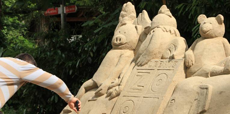 Ein Mann baut eine Sandskulptur.